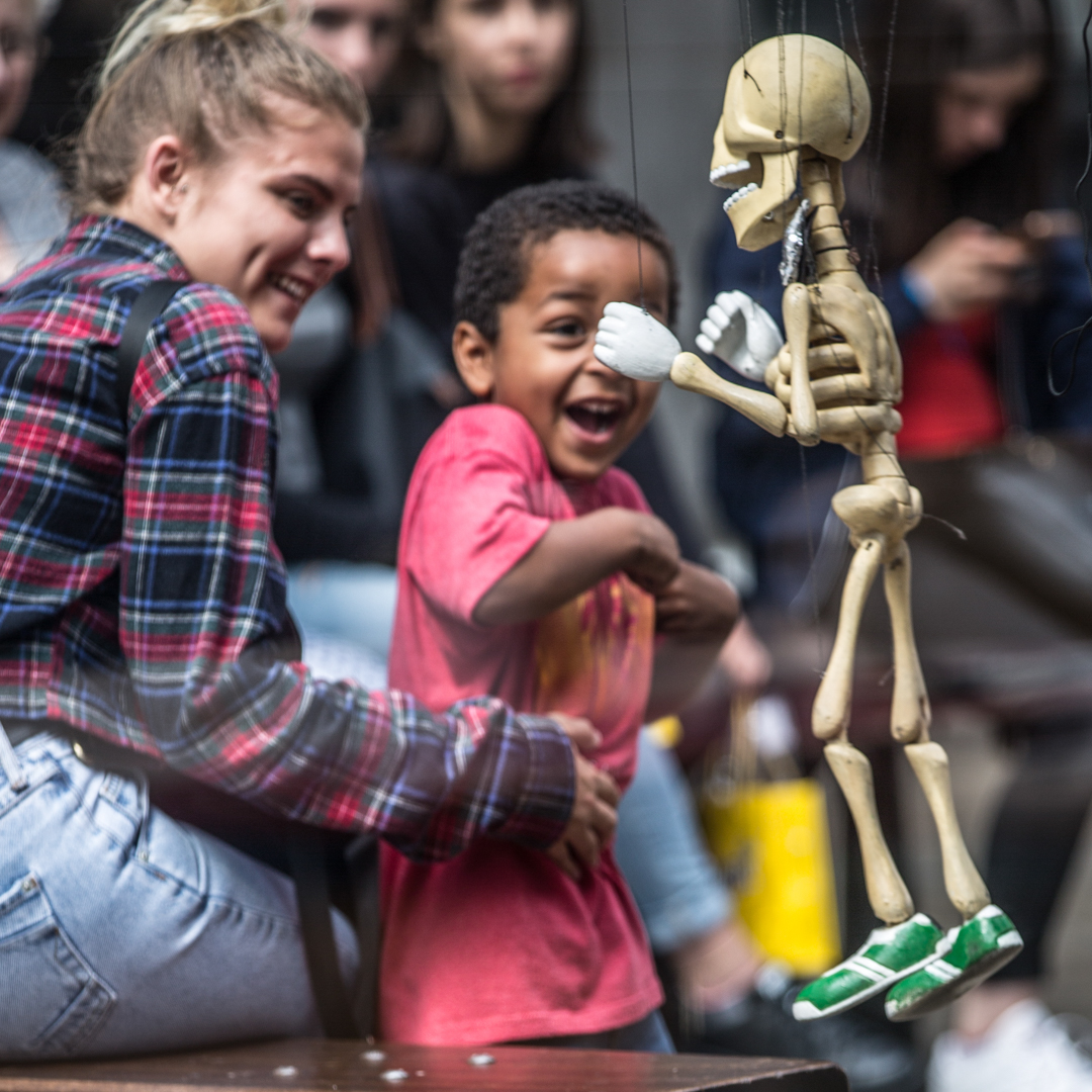 young boy scared of a puppet of a skeleton in London