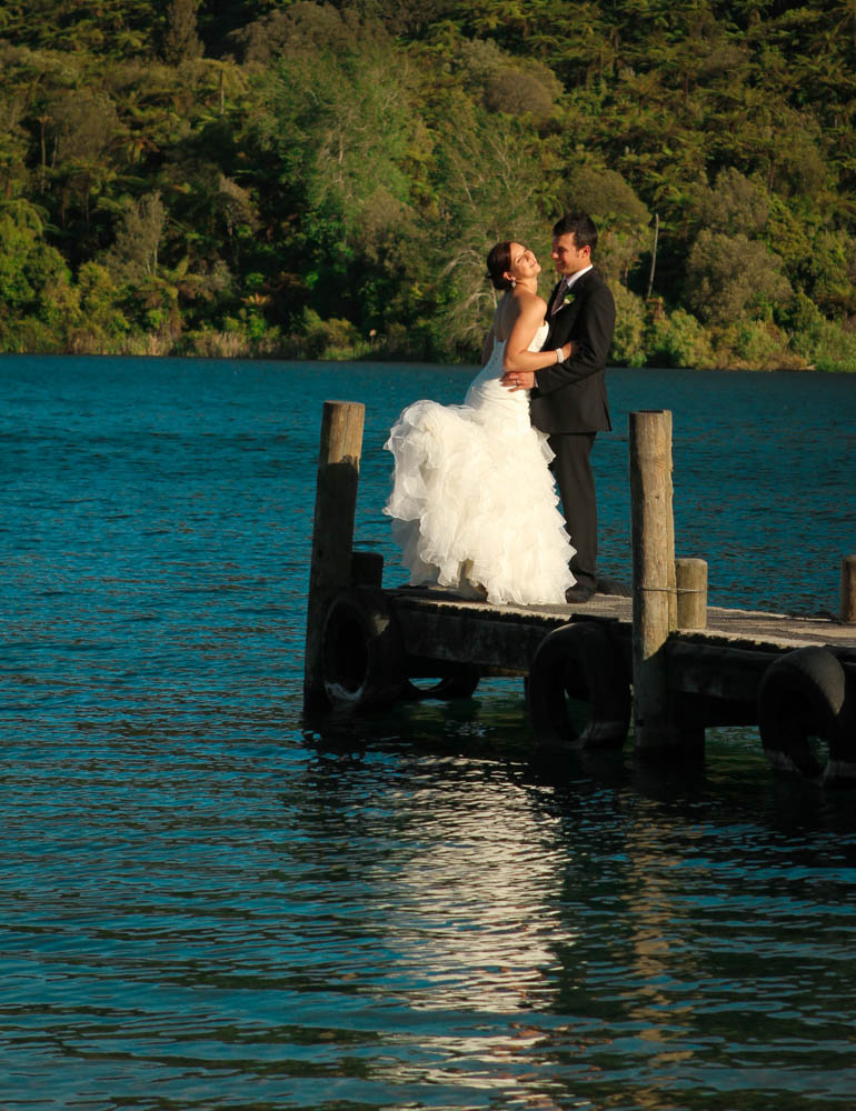 bridal couple kissing on the jetty at Lake Tarawera 