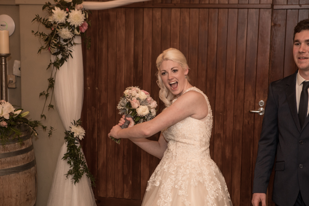 brides pretending to play baseball with her bouquet 