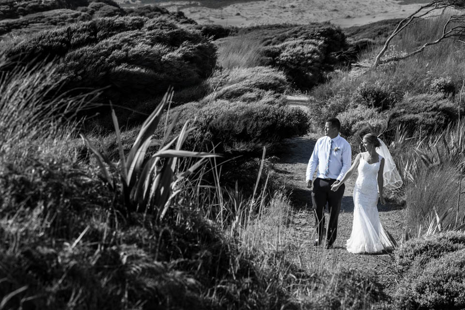 bride and groom in the sand dune in Opononi